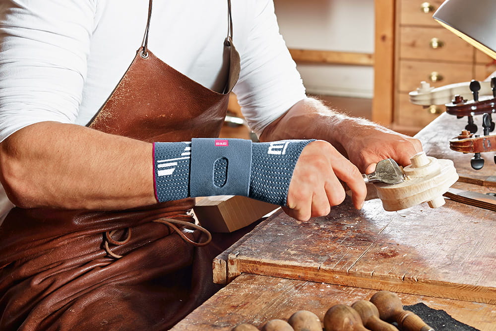 Ein Handwerker der Instrumente herstellt mit einer Handbandage