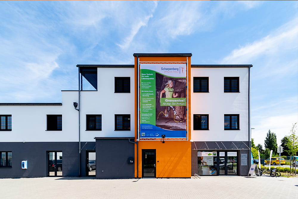 Seitenansicht unserer Zentrale mit großem Werbebanner einer Läuferin mit Prothesen