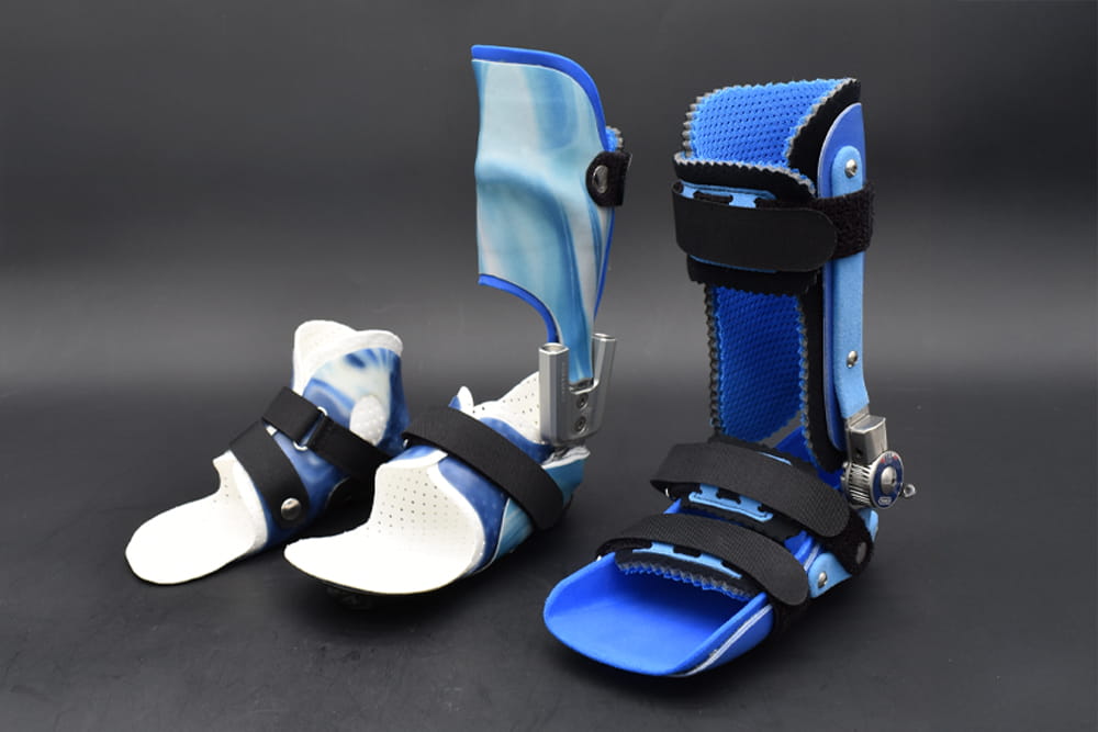 Eine Auswahl an blauen Kinderorthesen stehen in einer dunklen Umgebung.